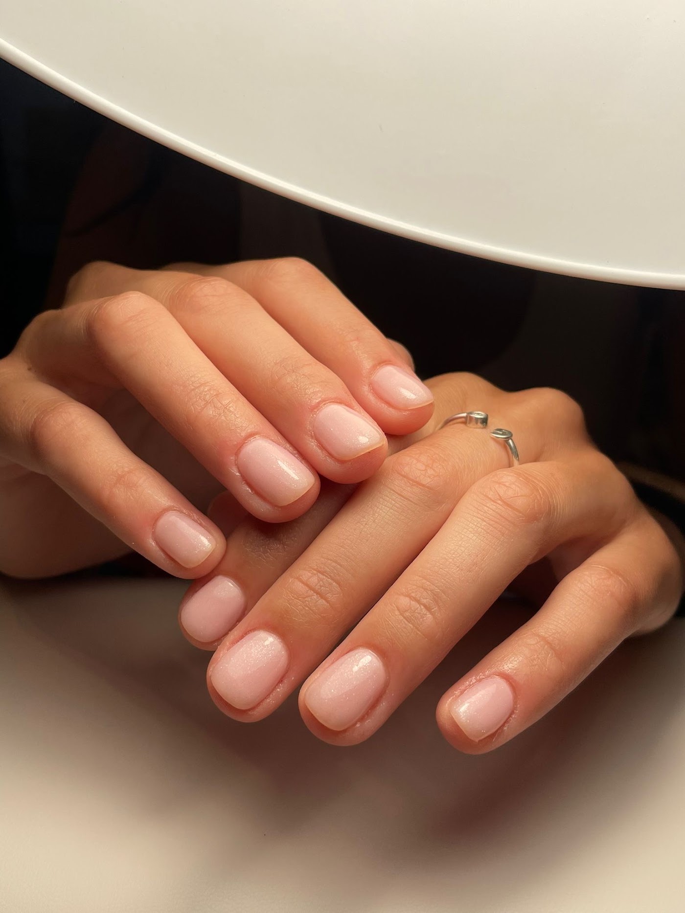 Manos con manicura en tono rosa suave